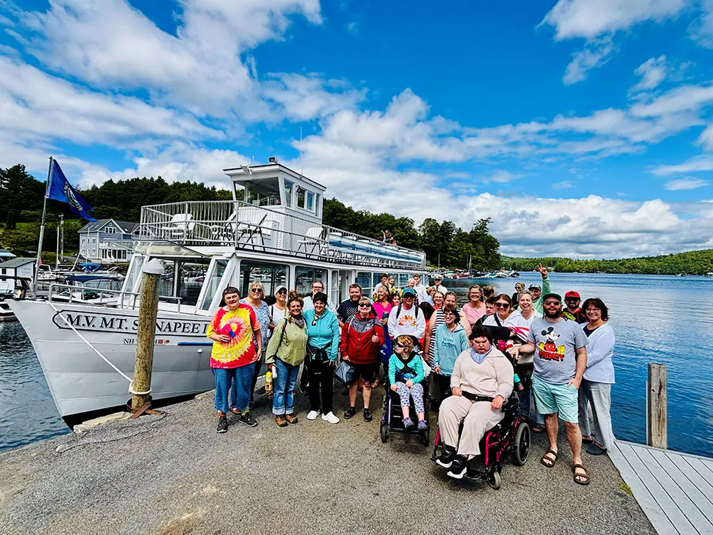A large group ready to board a cruise boat on Lake Sunapee