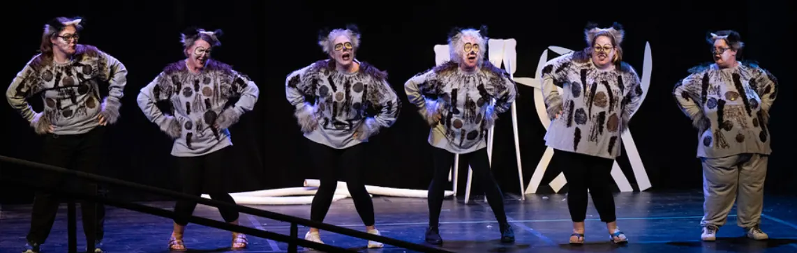 Six performers in hyena costumes on stage during The Lion King