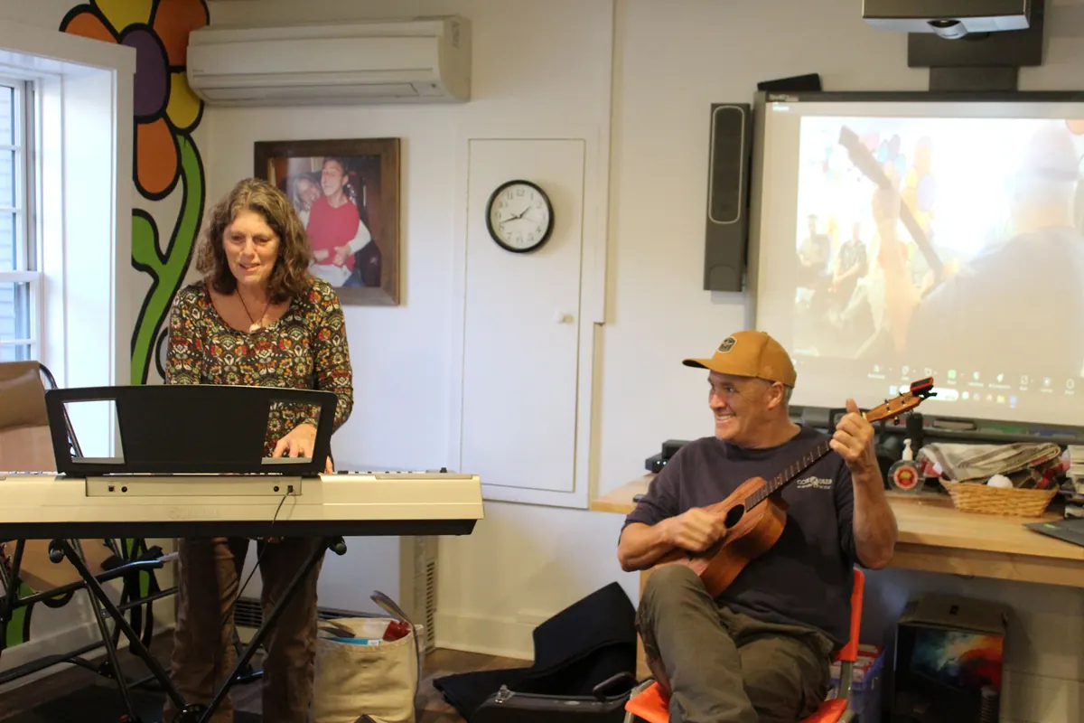 Kathleen playing the keyboard and Mark playing a ukulele during a music session at Zack's Place